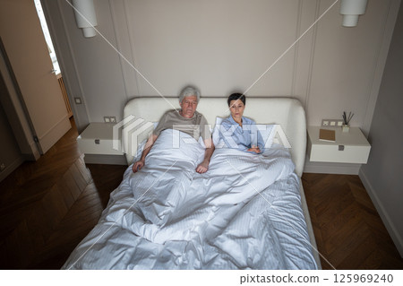 Long term partners showing strain in bed argument with frustrated woman reject touch, couple crisis Long term partners showing strain in bed argument with frustrated woman reject touch, couple crisis 125969240
