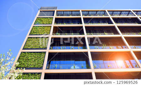 Green office building with plants on the facade. Ecology and green living in city, urban environment concept. Eco architecture.  125969526