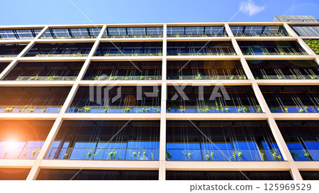 Green office building with plants on the facade. Ecology and green living in city, urban environment concept. Eco architecture.  125969529