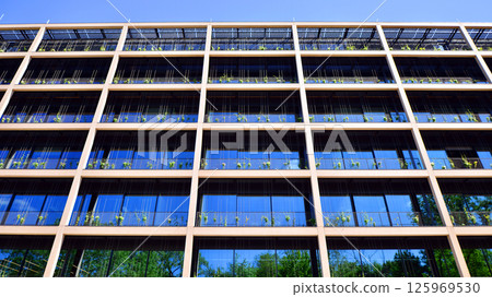 Green office building with plants on the facade. Ecology and green living in city, urban environment concept. Eco architecture.  125969530