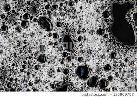 White soap foam bubbles on black background creating interesting texture 125969797