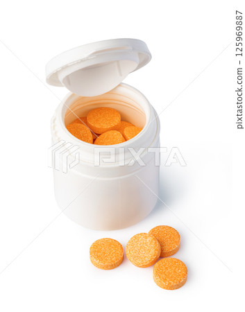 Open plastic pill bottle releasing orange vitamin C tablet on white background Open plastic pill bottle releasing orange vitamin C tablet on white background 125969887