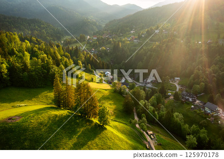 Calm idyllic village in Slovenian mountains at sunrise, summer travel concept Calm idyllic village in Slovenian mountains at sunrise, summer travel concept 125970178