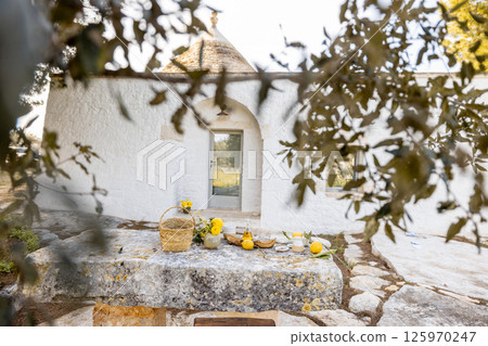 Trullo courtyard breakfast scene 125970247