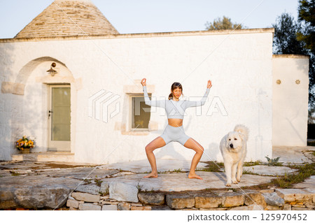 Morning Yoga Flow in Front of Trullo 125970452