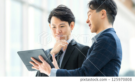 兩名男性商人使用平板電腦開會 兩名男性商人使用平板電腦開會 125970808