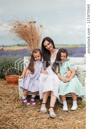 A mother with two daughters in a lavender field. A mother with two daughters in a lavender field. 125970948