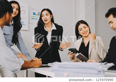 Team of financial advisory services. Asian advisor showing plan of investment to clients in the consultancy office. 125970990