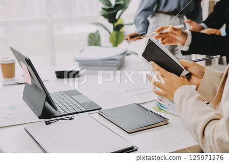 Team of financial advisory services. Asian advisor showing plan of investment to clients in the consultancy office. 125971276