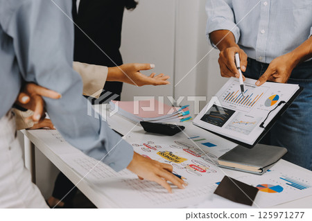 Team of financial advisory services. Asian advisor showing plan of investment to clients in the consultancy office. 125971277
