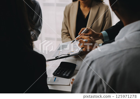 Team of financial advisory services. Asian advisor showing plan of investment to clients in the consultancy office. 125971278