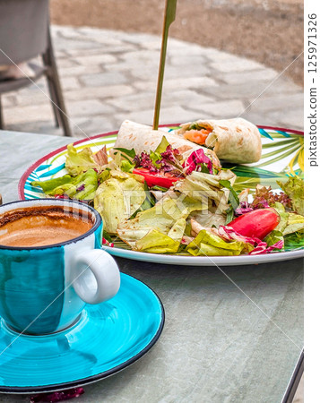 Fresh salad with tortilla wrap and a cup of mocha coffee — healthy lunch concept 125971326