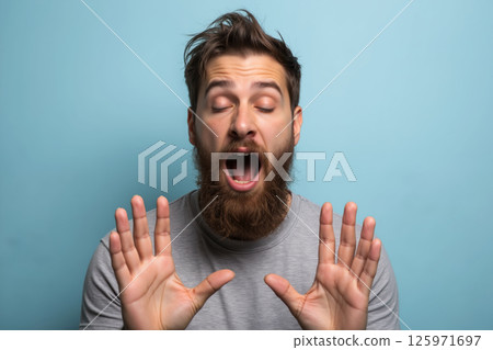 A man with a beard looks surprised with hands up. A man with a beard looks surprised with hands up. 125971697