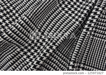 Black and white cage texture fabric. Winter cashmere scarf. Textile warm dark knitted cloth background. Black and white cage texture fabric. Winter cashmere scarf. Textile warm dark knitted cloth background. 125971827