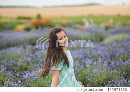 A beautiful girl in a beautiful green dress on a lavender field. A beautiful girl in a beautiful green dress on a lavender field. 125971880