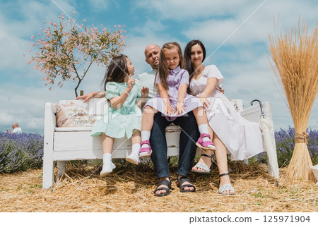 Children with their parents are resting on a lavender field. Children with their parents are resting on a lavender field. 125971904