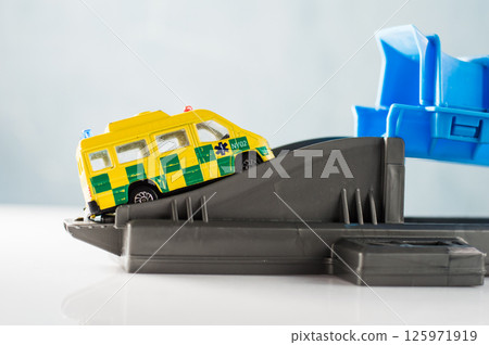 Plastic track with a yellow ambulance. 125971919