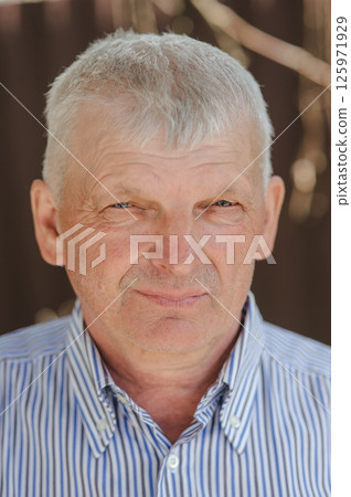 Portrait of a pensioner in a shirt. A man of retirement age is smiling beautifully.  125971929