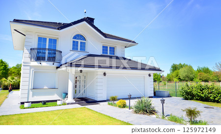 Luxury real estate single family house with white modern facade. A suburban district of single-family homes. 125972149