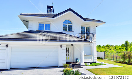 Luxury real estate single family house with white modern facade. A suburban district of single-family homes. 125972152
