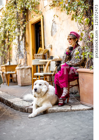 Woman with dog at rustic Roman cafe Woman with dog at rustic Roman cafe 125972473