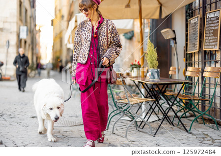 Woman walking dog on Roman street 125972484
