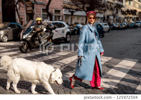 Woman walking dog in urban crosswalk Woman walking dog in urban crosswalk 125972504
