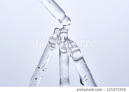 Four different face serum pipettes on a neutral background. Four different face serum pipettes on a neutral background. 125972956