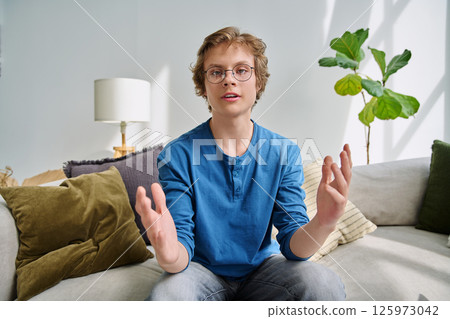 Webcam portrait male student teenager with glasses, sitting at home Webcam portrait male student teenager with glasses, sitting at home 125973042