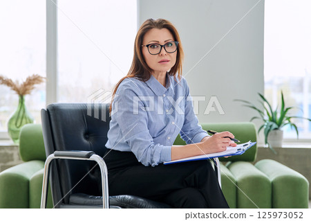 Portrait of professional psychologist therapist woman with clipboard in office Portrait of professional psychologist therapist woman with clipboard in office 125973052
