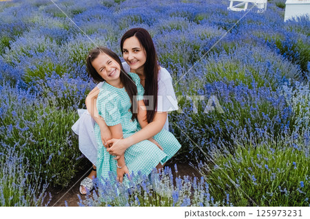 A beautiful European girl with a young woman in a field of purple flowers. 125973231