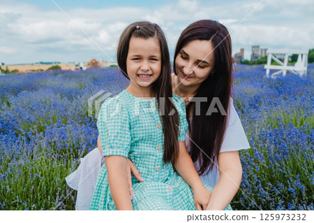 A beautiful European girl with a young woman in a field of purple flowers. 125973232