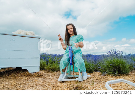 Girl swinging on a purple toy horse. Girl swinging on a purple toy horse. 125973241