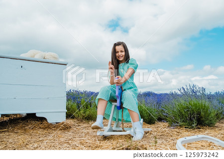 Girl swinging on a purple toy horse. Girl swinging on a purple toy horse. 125973242