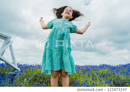 Child having fun on lavender field. Cute girl jumping high on the field covered with purple flowers. Child having fun on lavender field. Cute girl jumping high on the field covered with purple flowers. 125973247