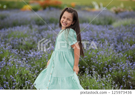 A little girl in a beautiful dress in a field. 125973436