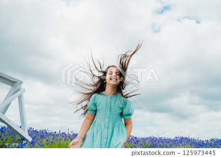 A little girl jumps high in a field of lavender. Fragrant lavender field. A little girl jumps high in a field of lavender. Fragrant lavender field. 125973445