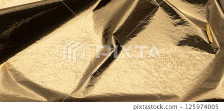 Golden foil sheet with reflective, shiny texture creates a chic, high-contrast design. Gold leaf Golden foil sheet with reflective, shiny texture creates a chic, high-contrast design. Gold leaf 125974005