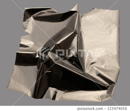 Silver foil crumpled with metallic, shiny texture creates an industrial, sculptural design. Wrinkled 125974058