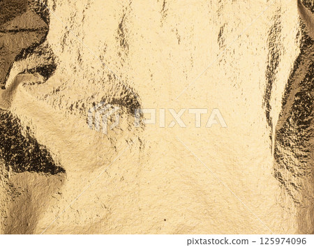 Elegant gold foil texture with subtle ridges and high-shine reflections, giving it a rich and Elegant gold foil texture with subtle ridges and high-shine reflections, giving it a rich and 125974096