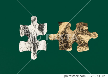 Gold and silver foil puzzle pieces with metallic texture represent contrast and mismatch, 125974104