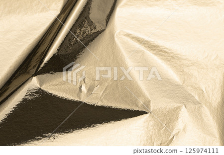 Gold foil texture with a crinkled surface, casting soft shadows. VIP-level shine and light 125974111