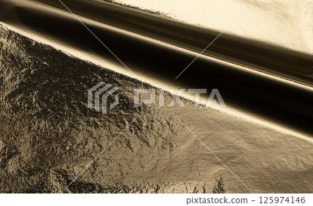 Gold metallic foil texture with a crumpled, folded surface. Shiny, reflective material with a rich 125974146