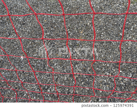 Red Mesh Fence Against a Gravel Surface in a Construction Area 125974391