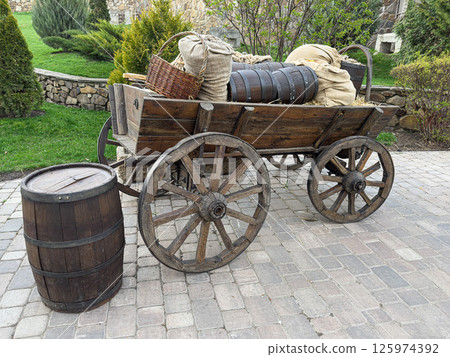 Rustic Wooden Cart With Barrels and Sacks in a Garden Setting 125974392