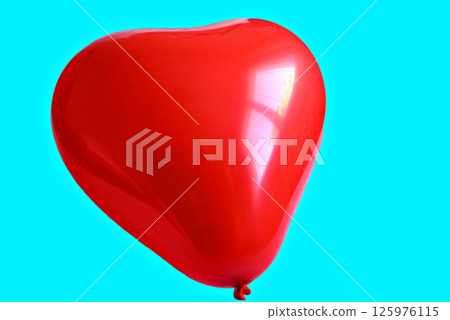 Red heart-shaped balloon on a turquoise background Red heart-shaped balloon on a turquoise background 125976115