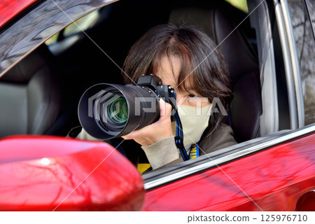 A woman taking a picture with a camera 125976710