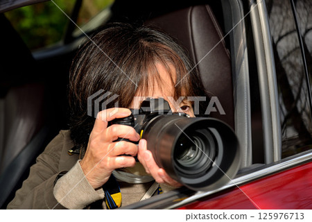 A woman taking a picture with a camera A woman taking a picture with a camera 125976713