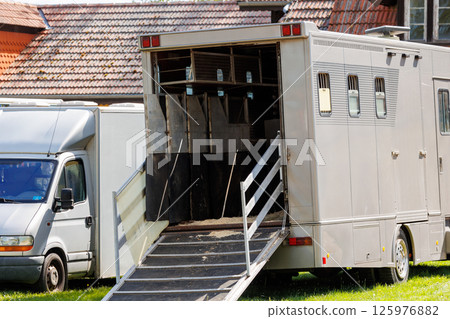 Horse box cargo trailer transport with open tailgate with hay and manure and horse transportation van at farm or ranch. Horsebox carriage lorry animal livestock tranport haulage 125976882
