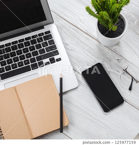 辦公桌上配備筆記型電腦和智慧型手機的遠端工作場景 辦公桌上配備筆記型電腦和智慧型手機的遠端工作場景 125977159